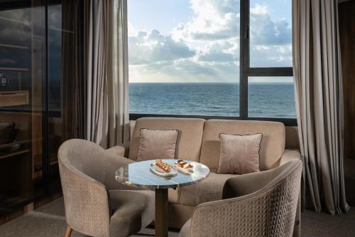 a living room with a couch and a table with food on it at Idou Malabata Beach and SPA in Tangier