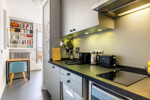 - une cuisine avec un comptoir et une cuisinière dans l'établissement GuestReady - A glamorous sight over the city, à Paris