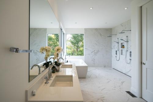 Un baño con dos lavabos, una bañera y una ducha. en Villa Summit Movie Theater Game room Views Hot Tub & Sauna, en La Conception