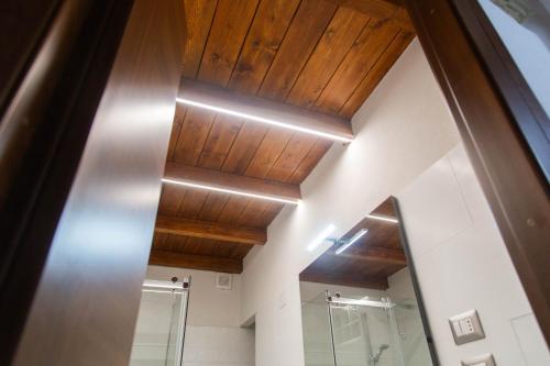 a bathroom with a wooden ceiling and a mirror at Domu Mena - Domusnovas in Domusnovas