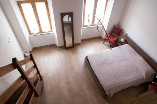a room with a bed and a chair and windows at Domu Mena - Domusnovas in Domusnovas