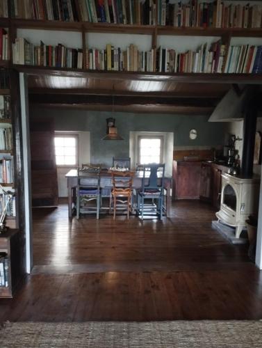 a dining room with a table and chairs and books at Entre Terre et Ciel. in Saignon