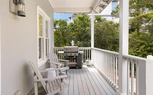 a white porch with two chairs and a grill at Ritz Clareon by Oversee 30A in Seacrest