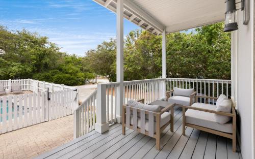 a porch with two chairs and a swing at Ritz Clareon by Oversee 30A in Seacrest
