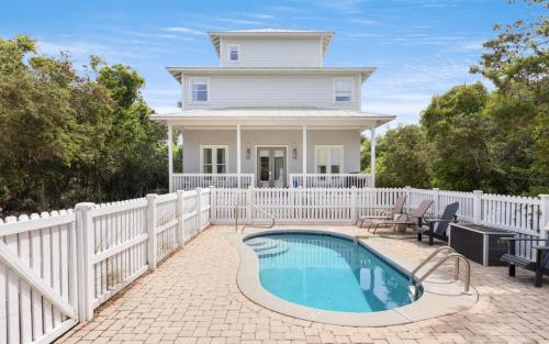 a house with a white fence and a swimming pool at Ritz Clareon by Oversee 30A in Seacrest