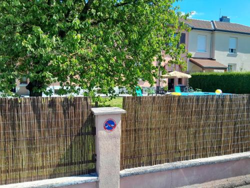 a fence with a blue sign on it next to a house at Maison standing vacances professionnel in Givet