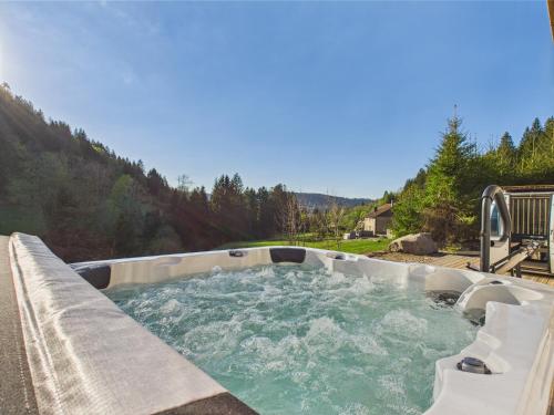 a hot tub with water in it in a backyard at Le Petit Paradis, Spa-Sauna and Gym in Gérardmer
