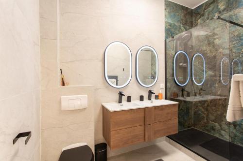 La salle de bains est pourvue d'un lavabo et de 4 miroirs. dans l'établissement #55 Sun terrace AC & Wifi 10mins walk to Sea & oldtown, à Nice