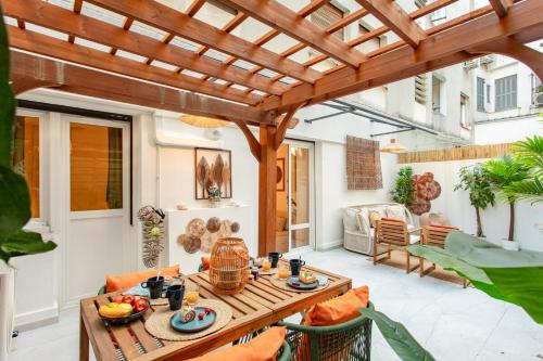 une terrasse avec une pergola en bois et une table dans l'établissement #55 Sun terrace AC & Wifi 10mins walk to Sea & oldtown, à Nice