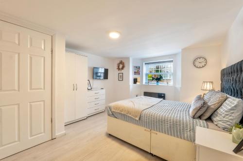 ein Schlafzimmer mit einem Bett und einer Uhr an der Wand in der Unterkunft Large One Bedroom Apartments Southsea Sleeps 3 - Free Parking in Portsmouth