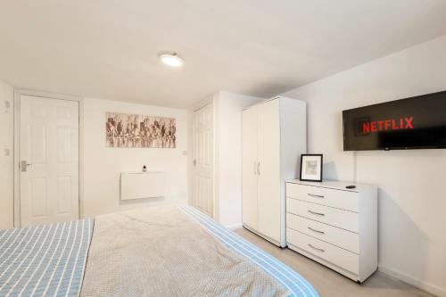 ein Schlafzimmer mit einem Bett und einem Fernseher an der Wand in der Unterkunft Large One Bedroom Apartments Southsea Sleeps 3 - Free Parking in Portsmouth