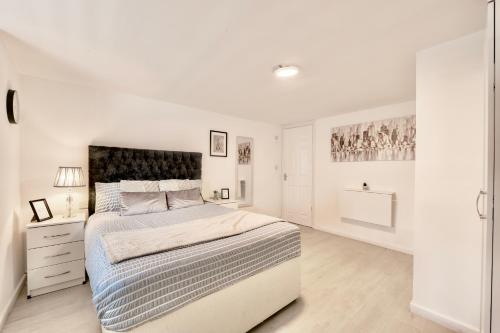 a white bedroom with a large bed and a dresser at Large One Bedroom Apartments Southsea Sleeps 3 - Free Parking in Portsmouth