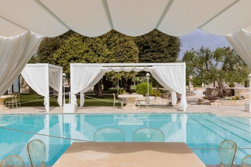 an outdoor wedding ceremony with a white canopy and a pool at San Marco Antico Relais - B&B in Bitonto