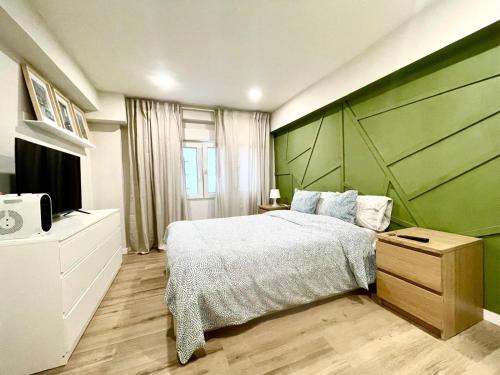 a bedroom with a large bed with a green headboard at Blue Room 25 in Bilbao