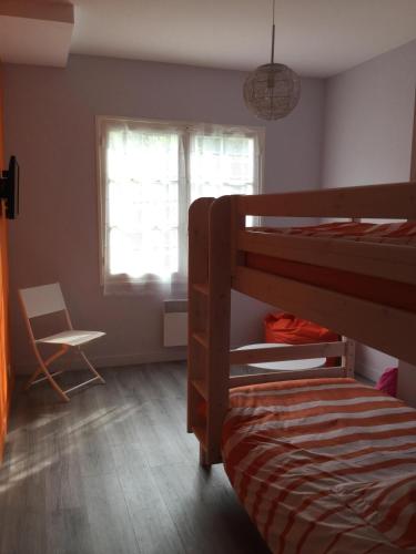 une chambre avec un lit superposé et une chaise dans l'établissement Totem Sud, à Arcachon
