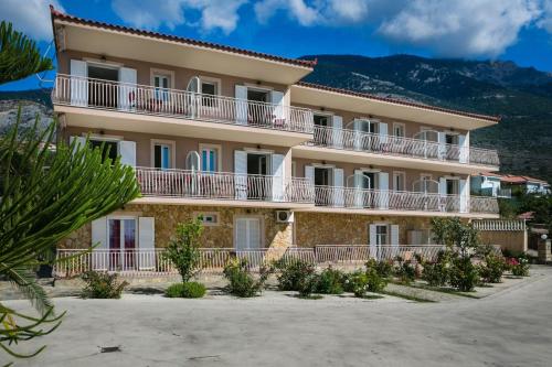 a large apartment building with balconies and trees at Lourdas View Studios in Vlachata