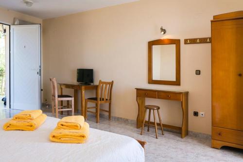 a bedroom with two beds and a desk and a mirror at Lourdas View Studios in Vlachata