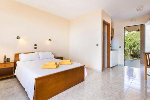 a bedroom with a bed with yellow towels on it at Lourdas View Studios in Vlachata