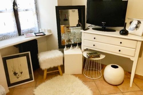 Cette chambre comprend une commode avec une télévision et un miroir. dans l'établissement Annecy, studio Cosy, à Annecy