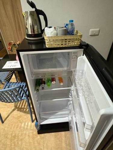 an empty refrigerator with its door open in a kitchen at Mamma Mia Rooms in Kata Beach