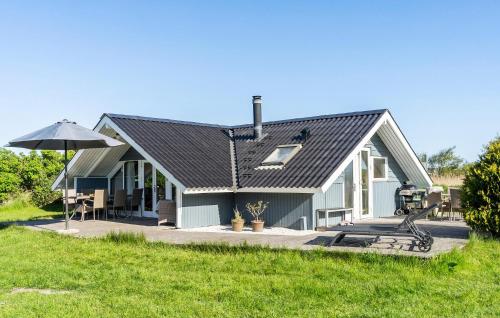 a house with an umbrella and a lawn at Holiday Home Romo Lxix in Bolilmark