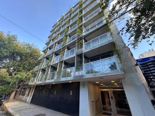 an apartment building with glass windows and a garage at Lure Palermo Hollywood in Buenos Aires