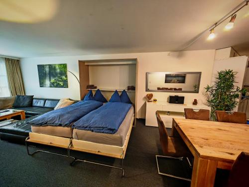 a bedroom with a bed and a couch and a table at 4 Zimmer 115m2 Gartenwohnung an der Jakobshorn Talstation neben Wander- und Mountainbikeparadise in Davos