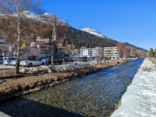 a river with cars parked next to a city at 4 Zimmer 115m2 Gartenwohnung an der Jakobshorn Talstation neben Wander- und Mountainbikeparadise in Davos