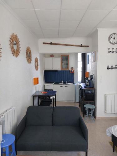 a living room with a couch and a kitchen at Les Vagues - Séjour Plage et Falaises au centre d'Etretat in Étretat