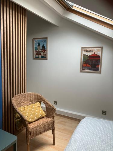 a bedroom with a wicker chair with a pillow on it at Studio centre-ville climatisé avec parking gratuit in Clermont-Ferrand