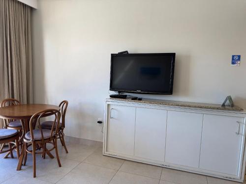 a flat screen tv sitting on top of a white cabinet at Destino Floripa Jurerê in Florianópolis