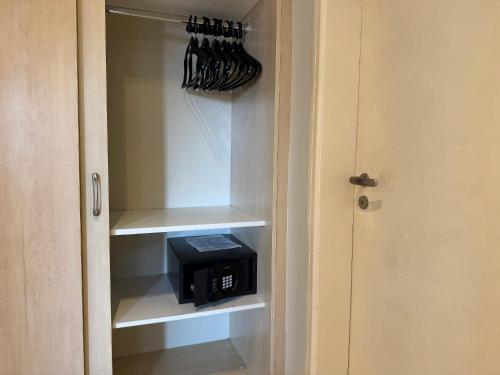 a cupboard with a microwave in a kitchen at Destino Floripa Jurerê in Florianópolis