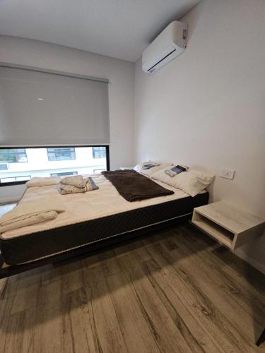 a bedroom with a large bed and a wooden floor at Alquiler Temporario Rosario 23 in Rosario