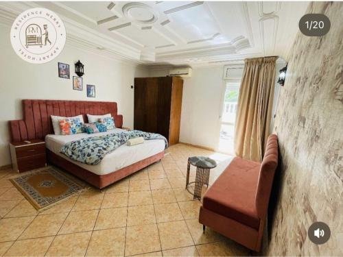 a bedroom with a bed and a couch and a chair at Merry Studio Hotel in Agadir