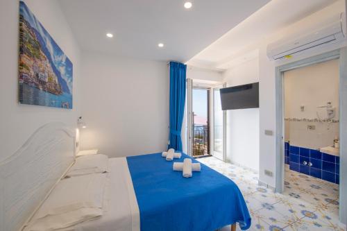 a bedroom with a blue bed and a large window at LA CASA DEL CAPITANO furore amalfi coast in Furore
