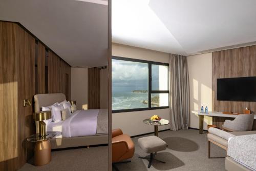 a hotel room with a bed and a view of the ocean at Idou Malabata Beach and SPA in Tangier