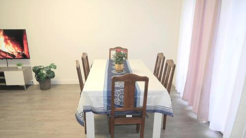a dining room table with a blue and white table cloth at Maison Cozy pour 6 personnes in La Grande-Paroisse