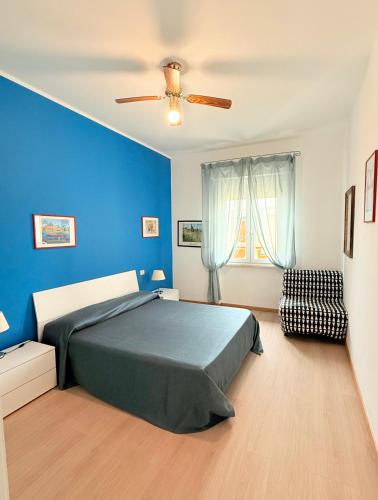 a bedroom with a bed and a blue wall at Ville Paola e Daniela in San Vincenzo