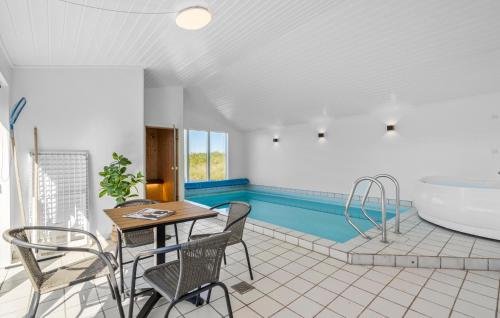 a bathroom with a tub and a table and chairs at Awesome Home In Ringkøbing With Sauna in Ringkøbing