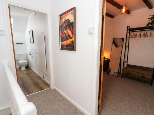 Un pasillo con un baño y un cuadro en la pared. en 4 Old Tanrhiw, en Caernarfon