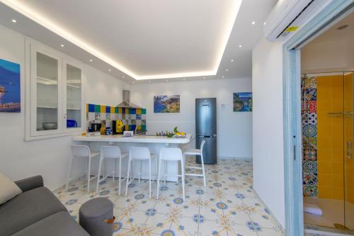 a kitchen with a bar with stools and a refrigerator at LA CASA DEL CAPITANO furore amalfi coast in Furore