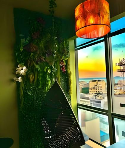 a vase with flowers in it next to a window at Vista deslumbrante e conforto em Ipanema in Rio de Janeiro