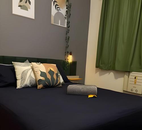 a bedroom with a bed with pillows and a green curtain at Vista deslumbrante e conforto em Ipanema in Rio de Janeiro
