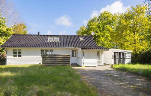a white house with a black roof at Amazing Home In Orø With Kitchen in Orø