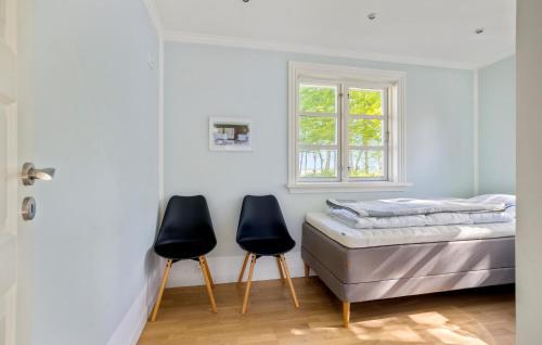 two chairs in a bedroom with a bed and a window at Amazing Home In Orø With Kitchen in Orø
