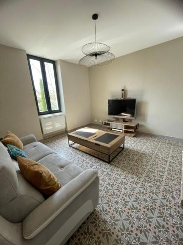 un salon avec un canapé et une télévision dans l'établissement DANS LES ALPILLES - 2 chambres ST REMY, à Saint-Rémy-de-Provence