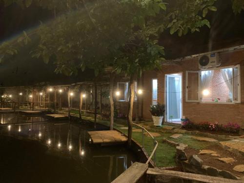 a house with lights in the water at night at Suối Xanh Garden in Gia Nghĩa