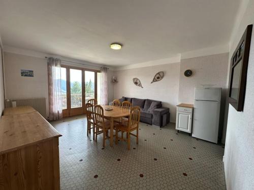 - une cuisine et une salle à manger avec une table et un canapé dans l'établissement Le Balcon Ensoleillé, à Font-Romeu