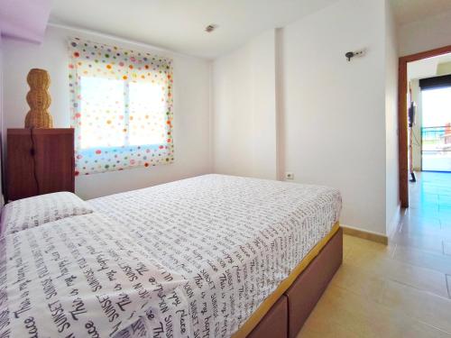 a bedroom with a large bed and a window at Apartamento con terraza en Playa Grau de Moncofa in Moncófar