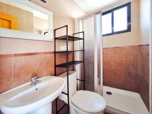 a bathroom with a white toilet and a sink at Apartamento con terraza en Playa Grau de Moncofa in Moncófar
